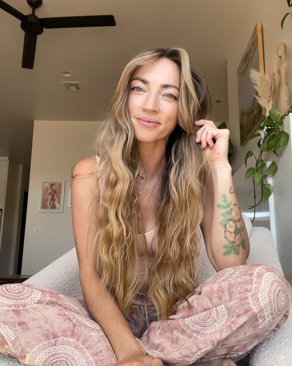 Chandra smiling, sitting cross-legged at home