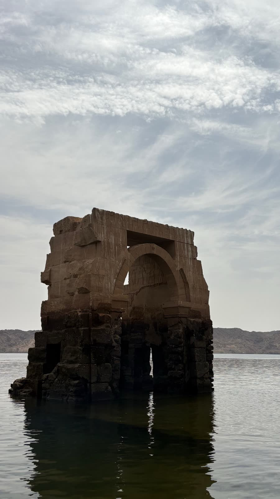A lone ancient stone ruin rising out of still water